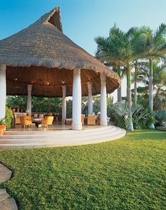 a gazebo with chairs and tables in the grass