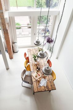 an overhead view of a dining room table with chairs and potted plants on it