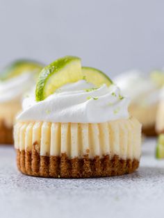 several small desserts with lime slices and whipped cream on top, sitting next to each other