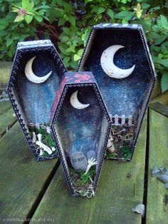 two vases sitting on top of a wooden table covered in grass and moon decorations