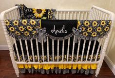 a baby crib with sunflowers and black and yellow bedding on it