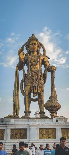 people are standing in front of a large statue