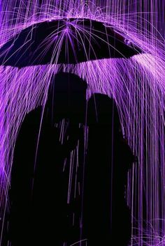 the silhouette of a person holding an umbrella in front of a purple background with lines