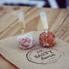 two donuts sitting on top of a brown paper bag