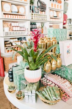 a white table topped with lots of different types of cards and vases filled with flowers