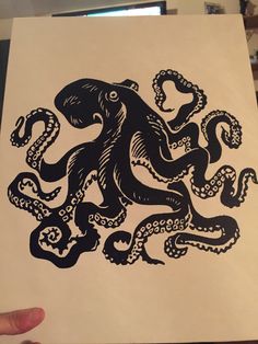 an octopus print is being held up by someone's hand