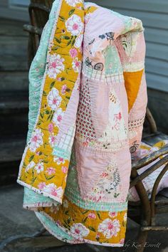 an old chair is covered with quilts on it's back and sides,