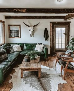 a living room filled with green couches and wooden tables