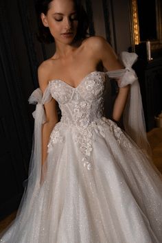 a woman in a white wedding dress is posing for the camera