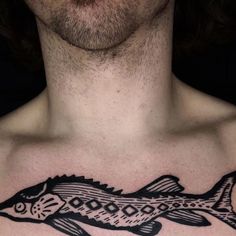 a man's chest with a fish tattoo on his chest and the bottom part of his chest