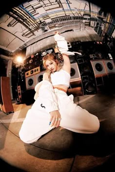 a woman sitting on the ground in front of a bunch of sound equipment with her arms up