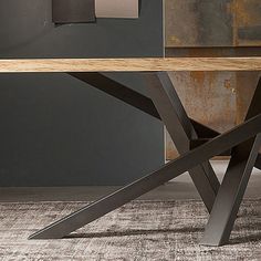 a wooden table sitting on top of a carpeted floor next to a metal wall