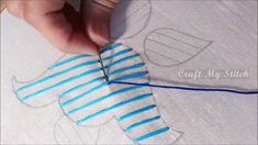 someone is cutting fabric with scissors on a piece of white cloth that has blue stripes