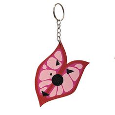 two key chains with pink and black designs on them, one is shaped like a leaf