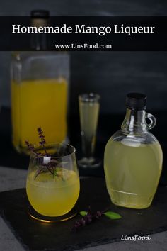 homemade mango liqueur in a glass next to a bottle and two glasses filled with liquid