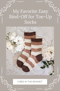 two pairs of socks sitting on top of a table next to white flowers and a lace doi