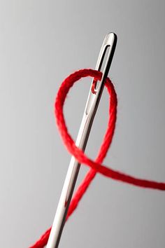 a pair of scissors with red string attached to them