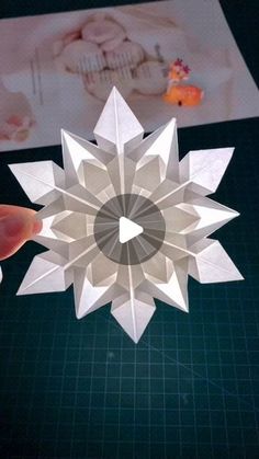 someone is making a paper snowflake that looks like a star ornament