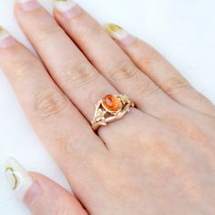 a woman's hand with an orange ring on it