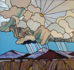 a stained glass window with clouds and mountains in the background