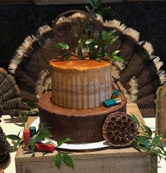 there is a cake on top of a wooden box with leaves and decorations around it