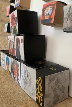 several boxes are stacked on top of each other in front of a wall with anime drawings