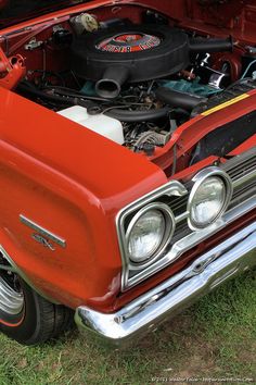 an old red car with its hood up and the engine in it's trunk