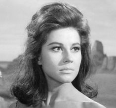 an old black and white photo of a woman with long hair in front of stonehenge