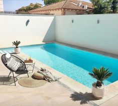 an empty swimming pool in the middle of a backyard with chairs and tables around it