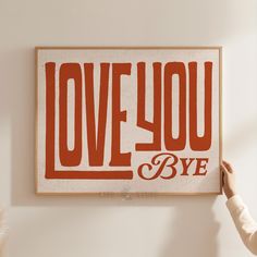 a person holding up a sign with the words love you and bye in red on it