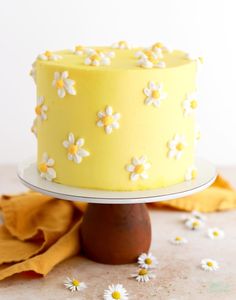 a yellow cake with white flowers on it