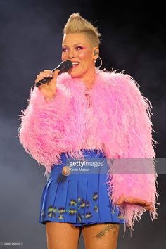 lady in pink fur coat and blue skirt performing on stage