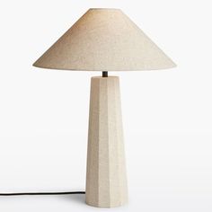 a lamp that is sitting on top of a table next to a white wall and floor