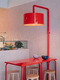 a red table and stools in a room