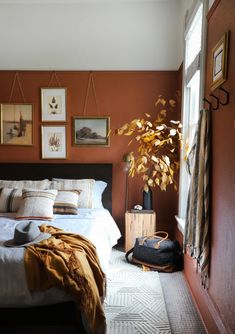 a bed sitting in a bedroom next to a mirror and a potted plant on top of a dresser