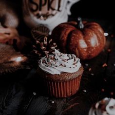 a cupcake with white frosting and sprinkles sits on a table