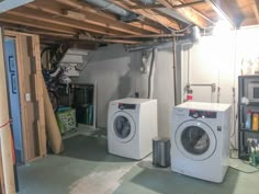 two washers and dryer in a room under construction