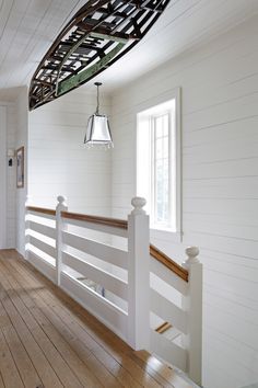 an empty room with white walls and wood floors