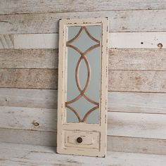 an old mirror hanging on the side of a wooden wall