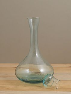 a glass vase sitting on top of a wooden table next to a pair of scissors