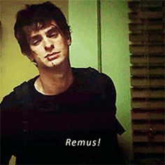 a man standing in front of a green wall with the words remus on it