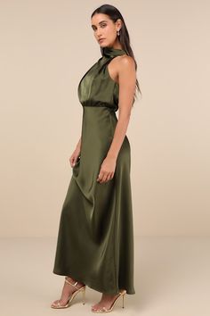 The Lulus Distinctive Charm Olive Green Satin Asymmetrical Maxi Dress is ready to party with the best (and most stylish) of them! Ultra-sleek woven satin shapes this chic dress that has a trendy mock neckline and a blousy, asymmetrical bodice with gathering. The fitted waist tops a figure-skimming, A-line maxi skirt. Top button closures secure atop a keyhole-style cutout at the back. Hidden back zipper/clasp. Fit: This garment fits true to size. Length: Floor length. Size medium measures 60.5" from shoulder to hem. Bust: Great for any cup size. Waist: Fitted - very fitted at natural waist. Hip: Loosely Fitted. Undergarments: May be worn with a strapless bra, adhesive bra, petals, or no bra. Fabric: Fabric has no stretch. Lined. Shell: 100% Polyester. Lining: 97% Polyester, 3% Spandex. Hand Satin Floor Length Dress, Olive Green Dress Outfit Wedding, Army Green Dresses, Army Green Dress Outfit, Green Dress Outfit, Long Dresses For Women, Asymmetrical Maxi Dress, Army Green Dress, Sleek Chic