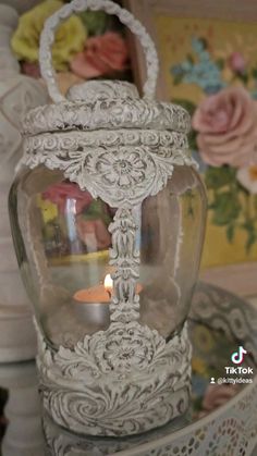 a glass jar with a candle inside on a table