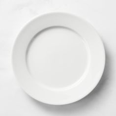 an empty white plate on a marble surface