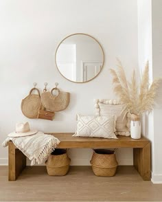 a wooden bench sitting under a mirror next to two baskets on top of a table