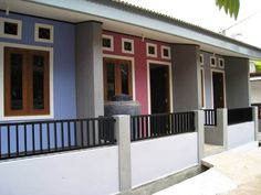 the front of a house with blue and pink walls