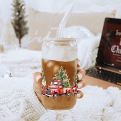 a person holding a glass with a drink in it and a laptop on the table