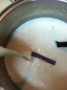 a spoon in a pot filled with milk