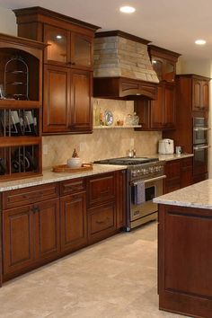 a large kitchen with wooden cabinets and stainless steel stove top oven in the center island