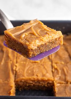 a piece of cake being held up by a spatula with peanut butter frosting on it